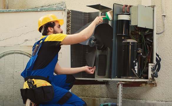 Technician checking external heat pump installation
