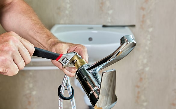 HVAC technician holding green pipe sealant for bathroom plumbing