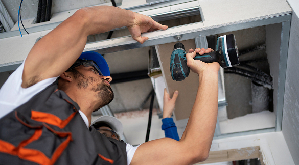 Technician installing pipes below kitchen sink