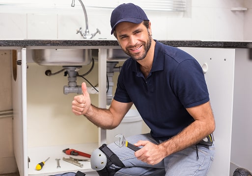Smiling HVAC technician next to water heater